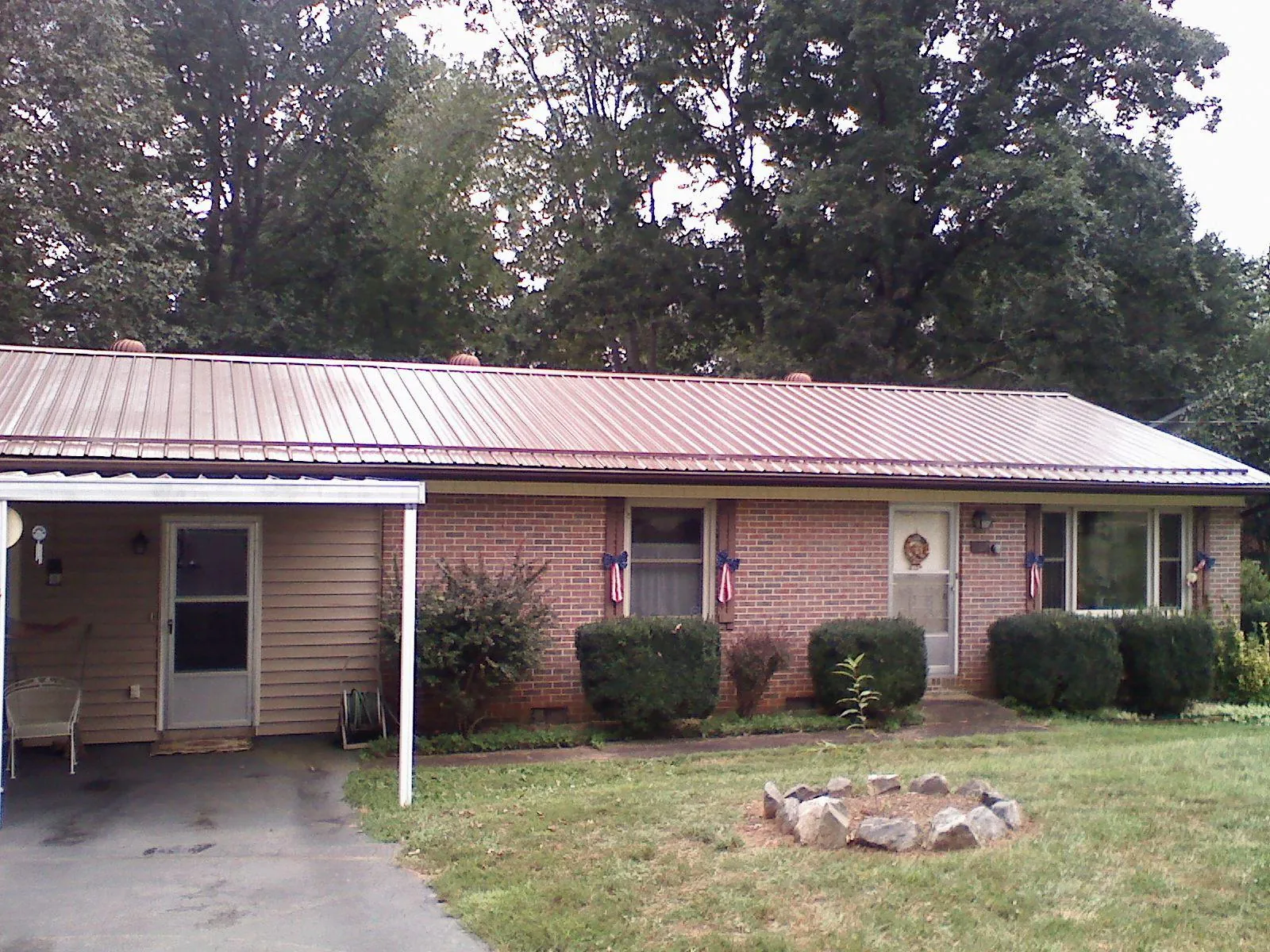Bronze metal roof and carport on a brick ranch home — Roof Repair work by our crew in White Earth